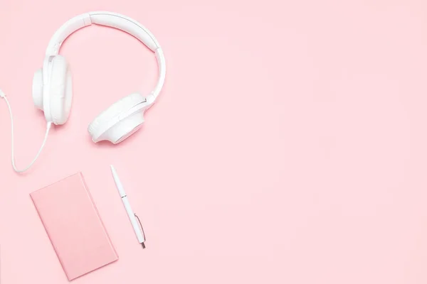 Pembe günlüğü, beyaz kalem ve pembe masa üzerinde beyaz kulaklık. Üstten görünüm. Minimalist düz blogcular, tasarımcılar, dergi vb kopya alanı ile kompozisyon yatıyordu