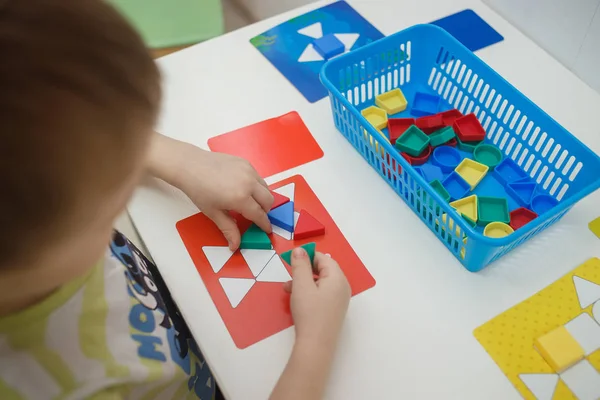 Niños jugando juegos educativos multicolores, mosaico y mesa de puzzles — Foto de Stock