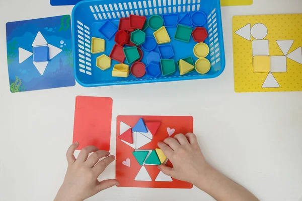 Niños jugando juegos educativos multicolores, mosaico y mesa de puzzles —  Fotos de Stock