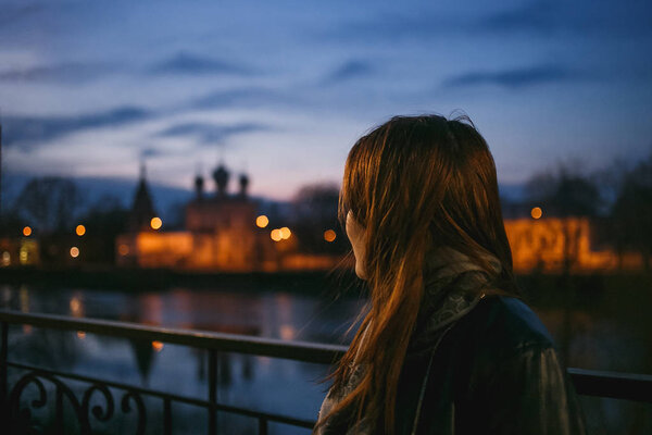 Young female looking to church domes evening Vologda city.
