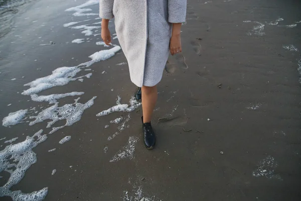 独自女孩穿着外套和皮靴沿着海滨行走 — 图库照片