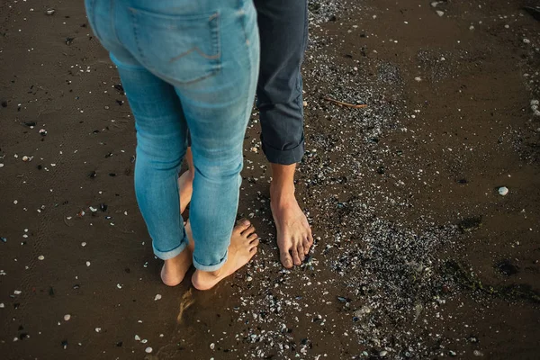 Una pareja joven se está divirtiendo y caminando por la costa del mar. Las piernas cierran. Cita romántica en la playa — Foto de Stock