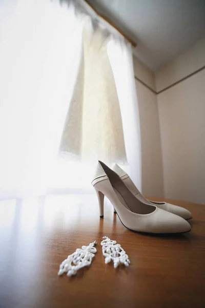 Casamento bonito sapatos de casamento, vestido de noiva e brincos — Fotografia de Stock