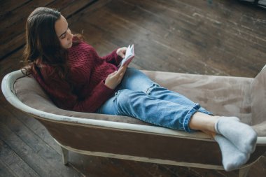 Genç kadın kanepe günlüğünü okuma