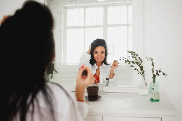 Belle femme caucasienne appliquant le maquillage à la chambre lumineuse — Photo