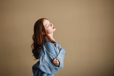 Bej arka planda Denim ceketli genç bayan model pozu. 1990 'ların Moda Yaşam Biçimi Kavramına Dön