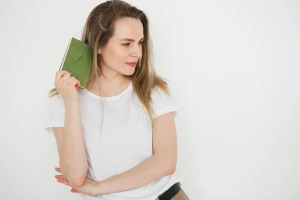 Portrét úspěšné usmívající se žena v oblečení s zelenou knihu o světlé pozadí — Stock fotografie