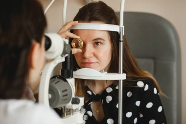 Arkhangelsk, Rusya-25 Mart 2019: çekici kadın doktor Oftalmolog modern klinikte genç kadının göz vizyonu kontrol ediyor. Doktor ve hasta Oftalmoloji Kliniği