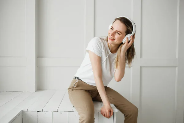 Aproveite a música. Jovem feliz música agradável em fones de ouvido brancos . — Fotografia de Stock