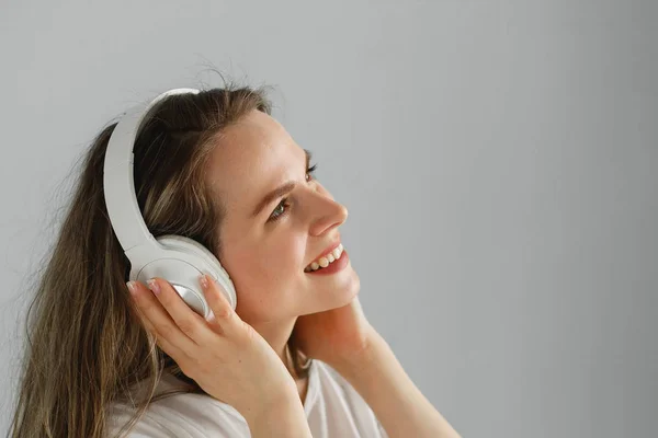 Nikmati musiknya. Wanita muda bahagia menyenangkan musik di headphone putih. — Stok Foto