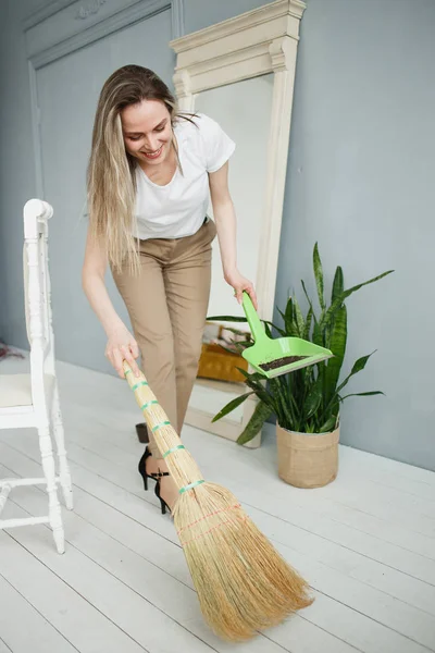 Partial view of woman in pink rubber gloves sweeping loose soil from under the pot — Stock Photo, Image