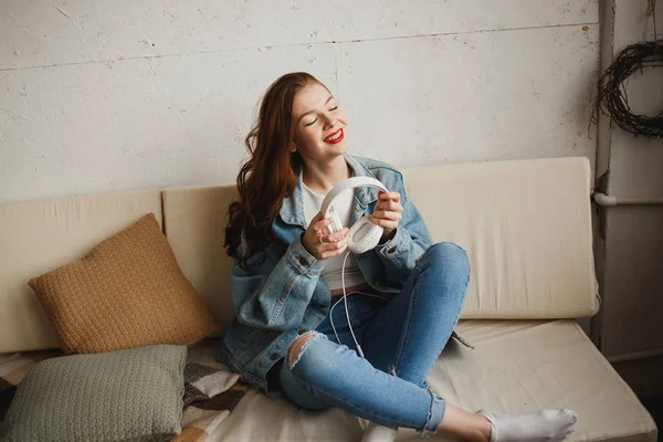 Jovencita con auriculares blancos y Pocket Pleer en el sofá Vista lateral. Cultura Hipster, Música del Amor, Fiesta de Danza de los 90 — Foto de Stock