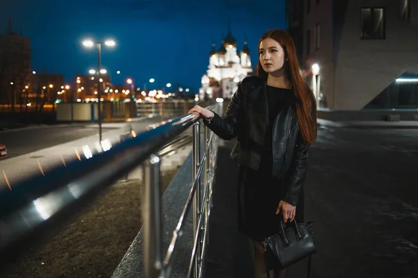 Mujer joven y solitaria de pie en la ciudad nocturna . — Foto de Stock