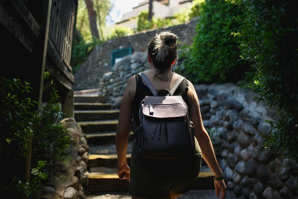 Junge Frau geht die Treppe der kleinen Straße der antiken Stätten hinauf — Stockfoto