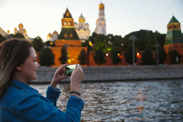 Touriste femme prenant des photos sur téléphone portable pendant le voyage en bateau sur la rivière Moscou sur le fond du Kremlin. Voyage en Russie concept — Photo