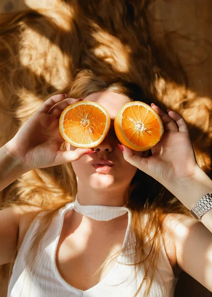 Piękno Ginger dziewczyna trwa Juicy pomarańcze. Piękne radosne teen girl Holding pomarańczowy plasterki i śmiać się emocje — Zdjęcie stockowe