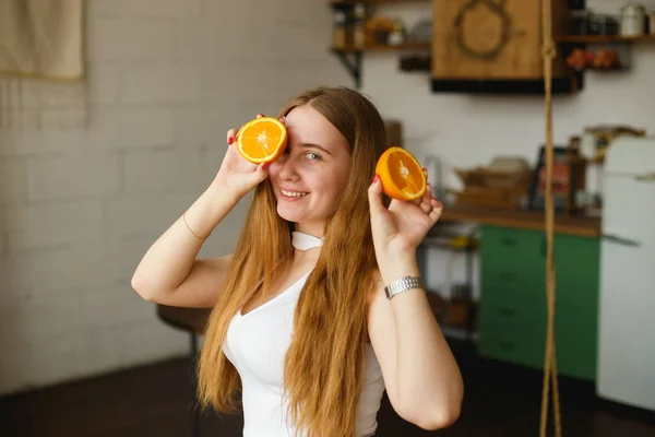 Beauty Ginger Girl toma naranjas jugosas. hermosa alegre adolescente chica celebración naranja rebanadas y riendo emociones — Foto de Stock