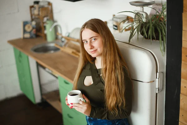 Hermosa joven pelirroja bebiendo té en la cocina por la mañana — Foto de Stock