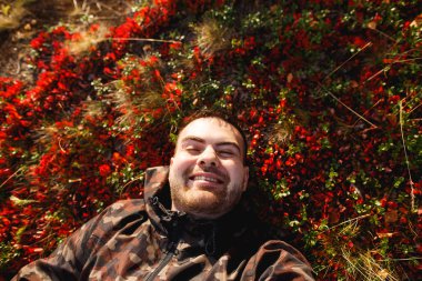 Sezon, mutluluk ve insan kavramı - gülümseyen genç adam zemin veya çim, yosun ve sonbahar tundra düşmüş yaprakları yalan