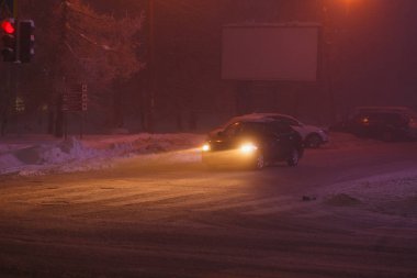 Şehirde kış yol trafiği. Soğuk bir kış akşamı nda arabaların farları
