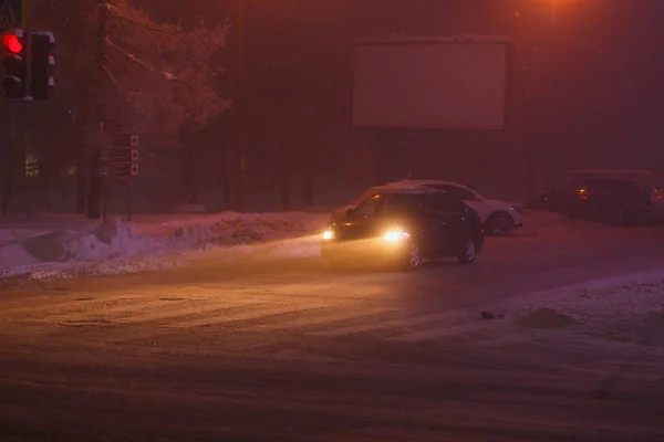 Lalu lintas jalan musim dingin di kota. Lampu depan mobil pada malam musim dingin — Stok Foto