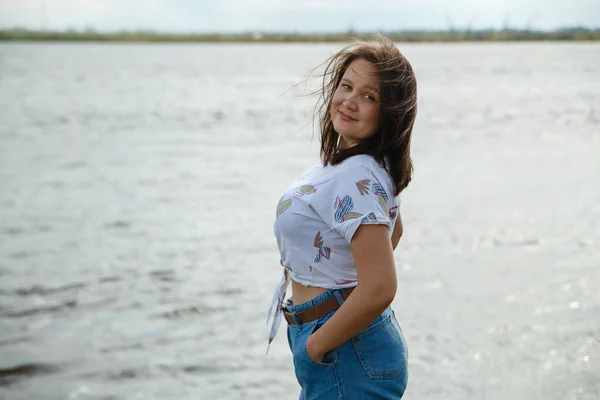 Nehir kıyısında sevimli tombul kadın portresi. Gerçek insanlar.