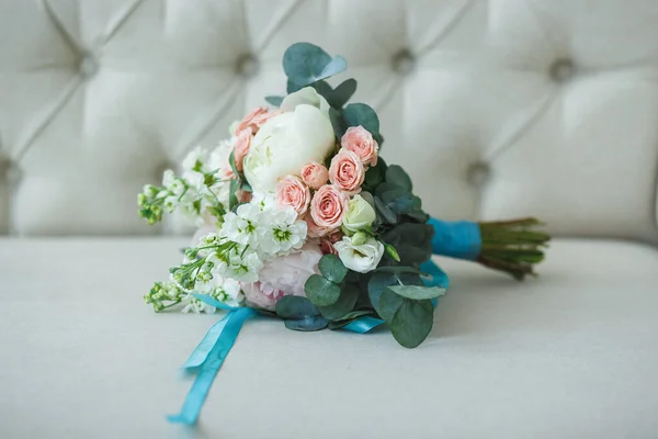Ramo de boda de rosas blancas, rosas rosadas y peonía con cinta turquesa en el sofá ligero — Foto de Stock