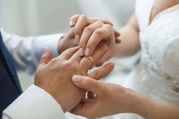 Novia poniendo un anillo de bodas en los novios dedo — Foto de Stock