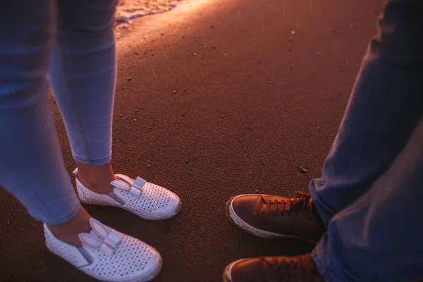 Деталь романтичної пари на прогулянці вздовж пляжу Сансет разом. Прекрасний захід сонця і краплі дощу. Хози і пісок крупним планом — стокове фото