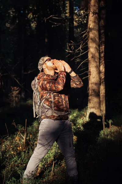 Senderismo en el bosque de otoño. Caminante masculino en camuflaje con mochila buscando un camino a casa en el bosque. Caucásico guapo macho al aire libre en la naturaleza. Concepto de desgaste forestal, navegación — Foto de Stock