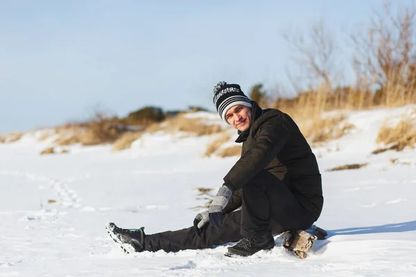 Junger Kaukasier in warmer Winterkleidung sitzt im Nadelwald in Nordrussland — Stockfoto