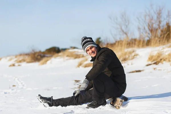 Jonge blanke man in warme winterkleding zittend in het naaldbos in Noord-Rusland — Stockfoto