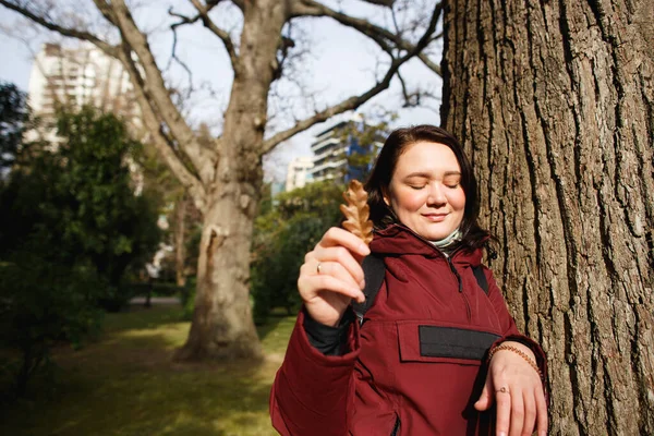 Женщина держит лист дуба в теплый день в весеннем парке — стоковое фото