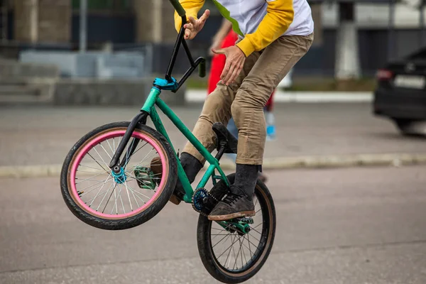 Bmx rider on black bmx in doing acrobtic stunts in the street. Urban male sports outdoor activity concept