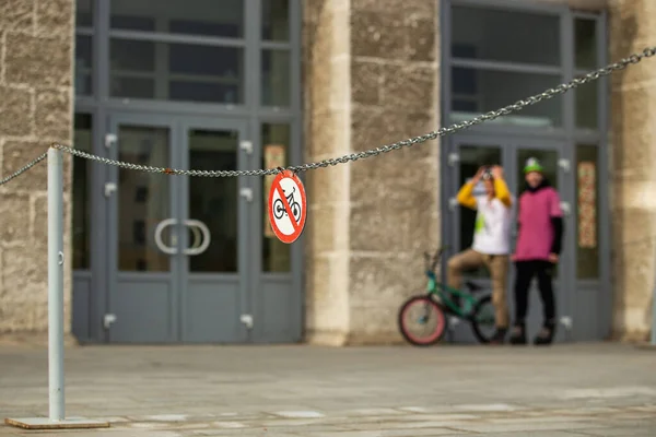 Красный знак остановки велосипеда на улице и городской экстрим bmx байкерсон на заднем плане — стоковое фото