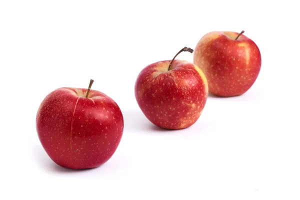 Three red apples on a white background. Juicy apples of red color with yellow specks on a white background. A group of ripe apples on an isolated background.