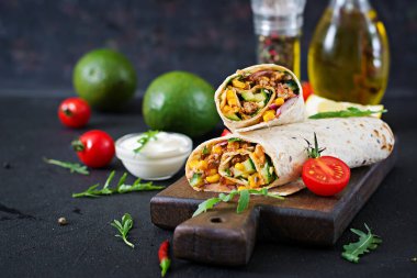Burrito sarar sığır eti ve sebze siyah arka plan üzerine
