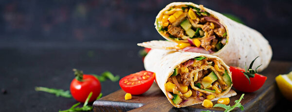 Burritos wraps with beef and vegetables on  black background