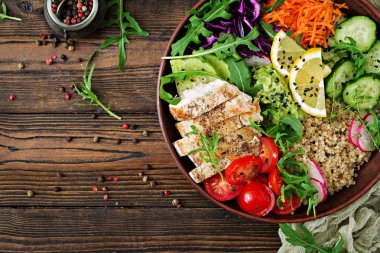 ızgara tavuk, quinoa, domates, guacamole, havuç, kırmızı lahana, salatalık ve roka salatası üstten görünüm 
