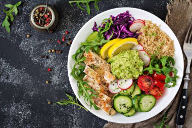ızgara tavuk, quinoa, domates, guacamole, havuç, kırmızı lahana, salatalık ve roka salatası üstten görünüm 
