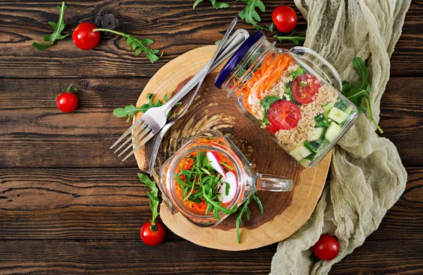 在木制的玻璃罐子里用奎奴亚 芝麻菜 西红柿和黄瓜做沙拉的顶级视图 — 图库照片