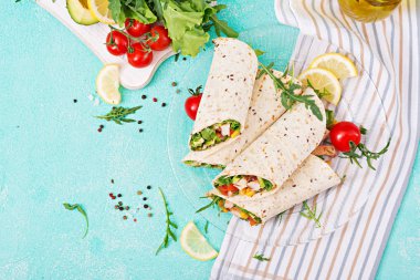 Burrito tamamladı tavuk ve sebze ışık arka plan üzerinde. Tavuk dürüm, Meksika yemeği. Üstten görünüm, düz yatıyordu