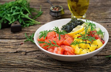 Hawaiian Somon Balık poke kaseyle pirinç, avakado, mango, domates, susam ve yosunlar. Buda kase. Diyet gıda.