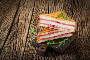 Club sandviç - panini jambon ve peynir ahşap arka plan üzerinde. Piknik gıda.