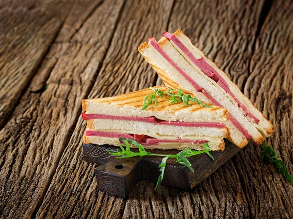 Club sandviç - panini jambon ve peynir ahşap arka plan üzerinde. Piknik gıda.