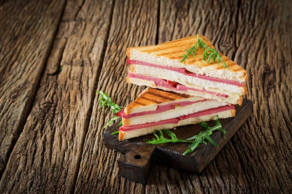 Club sandviç - panini jambon ve peynir ahşap arka plan üzerinde. Piknik gıda.