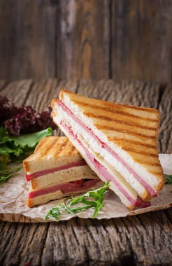 Club sandviç - panini jambon ve peynir ahşap arka plan üzerinde. Piknik gıda.