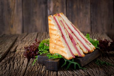 Club sandviç - panini jambon ve peynir ahşap arka plan üzerinde. Piknik gıda.