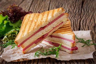Club sandviç - panini jambon ve peynir ahşap arka plan üzerinde. Piknik gıda.