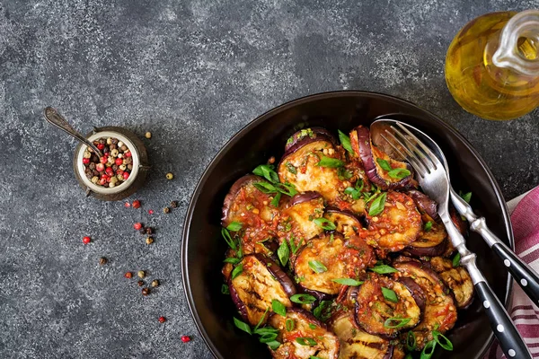 Patlıcan, domates sosu, sarımsak, kişniş ve nane ile ızgara. Vegan gıda. Izgara patlıcan. Üstten görünüm. Düz yatıyordu